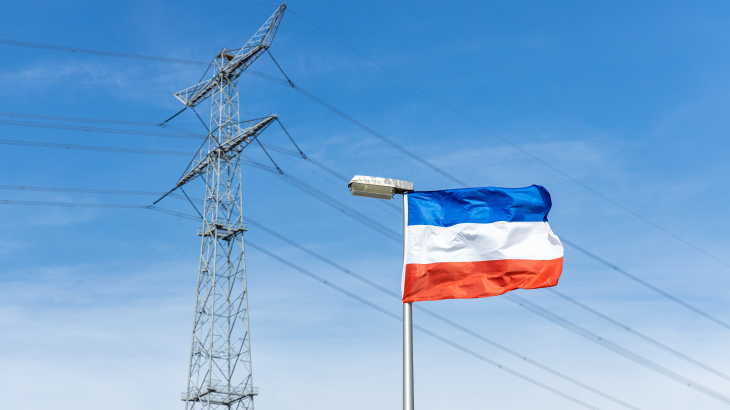 Een omgekeerde vlag in de buurt van een hoogspanningsmast