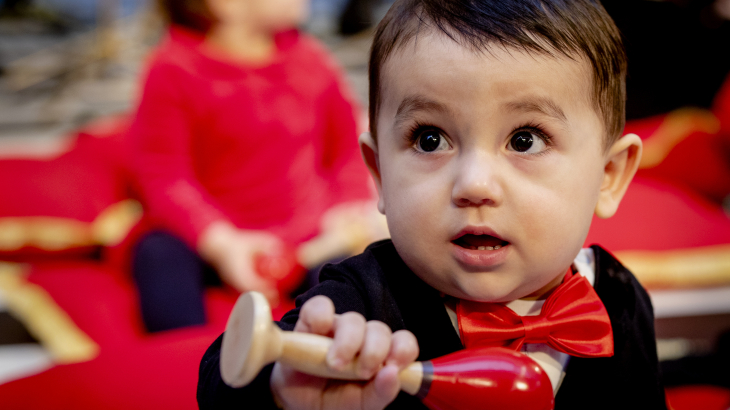 Een baby met een houten rammelaar 