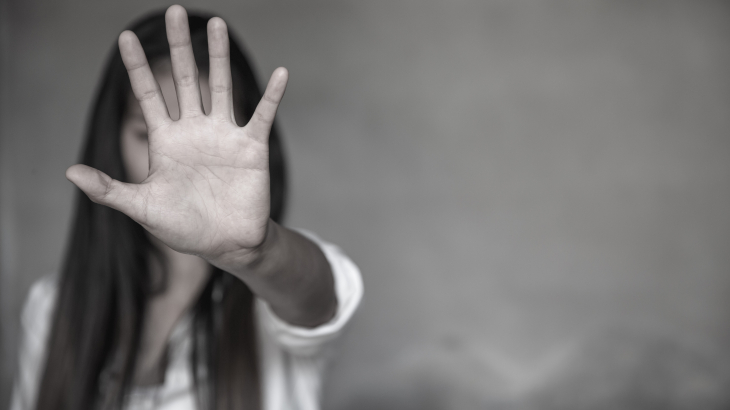 Een vrouw maakt met haar hand een stopteken.