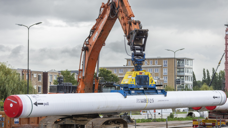 Een buis voor een warmtenet bij Rijswijk wordt in de grond gelegd. 