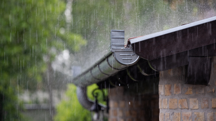 Regenwater valt neer in een dakgoot.