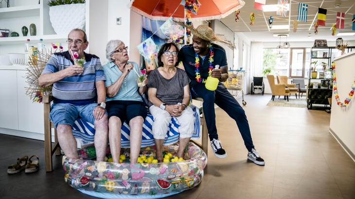 Bewoners van een verzorgingshuis in Zoetermeer zitten ter verkoeling met hun voeten in een zwembadje. Foto: Bart Maat (ANP)