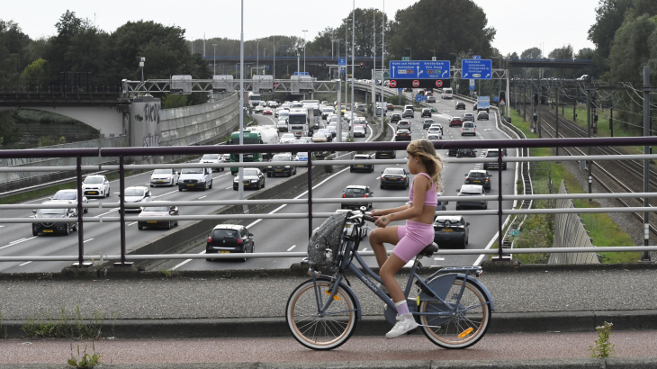 Een jonge fietser op het viaduct over de A20 bij Rotterdam.