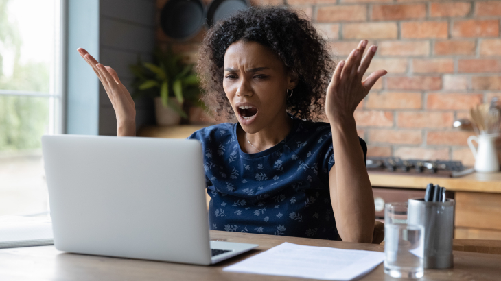 Vrouw kijkt boos of verbaasd naar computerscherm