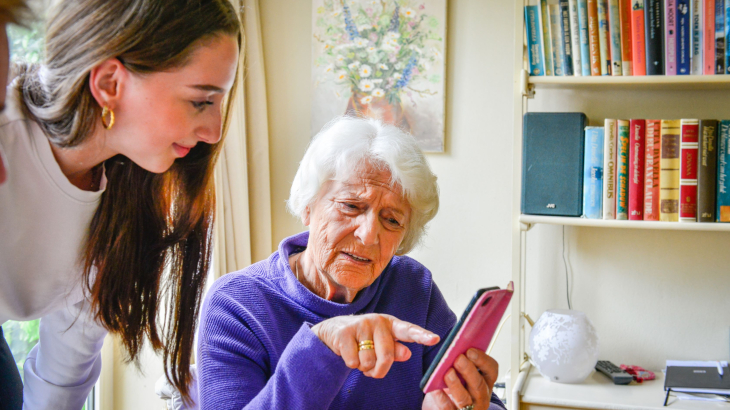 Kleindochter legt oma iets uit over de smartphone