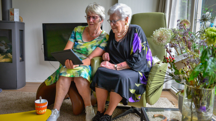 Bejaarde moeder en dochter bekijken een iPad