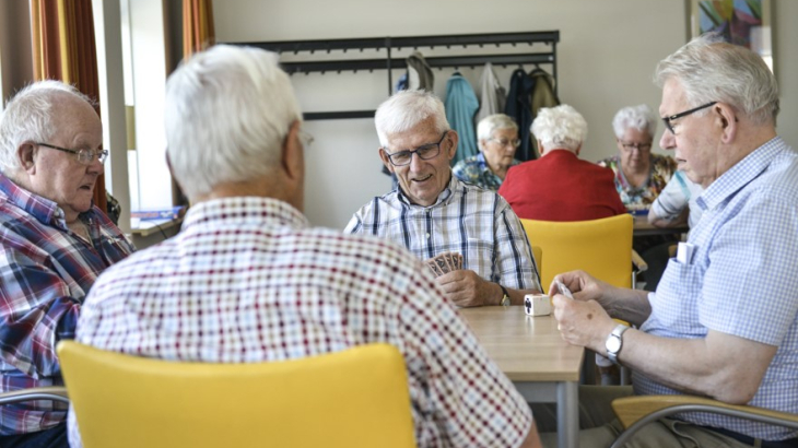 Ouderen klaverjassen in buurthuis