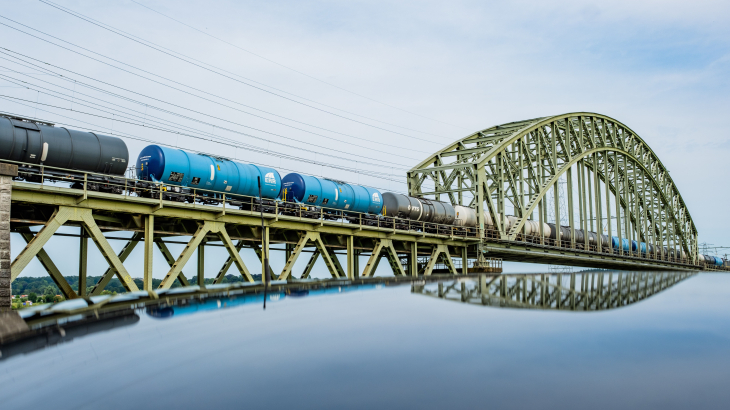 Een goederentrein rijdt over Spoorviaduct Oosterbeek over de Nederrijn. 