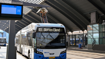 Een elektrische bus in Amsterdam wordt opgeladen.