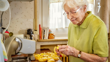 Oudere vrouw schilt aardappels