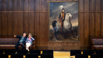 Bezoekers in een zaal van de Raad van State tijdens een open dag begin juni. Naast hen een portret van Willem II.