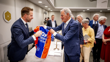 Demissionair minister Hugo de Jonge kreeg dinsdagmiddag van 50Plus-senator Martin van Rooijen een shirt van wielerclub Door Oefening Flink, waar veel (oud-)politici bij zitten.