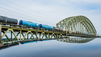 Een goederentrein rijdt over Spoorviaduct Oosterbeek over de Nederrijn. 