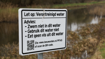 Een waarschuwingsbord langs een sloot met PFOS bij de vliegbasis Leeuwarden.